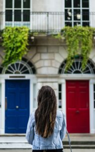 femme devant une porte rouge et une porte bleue